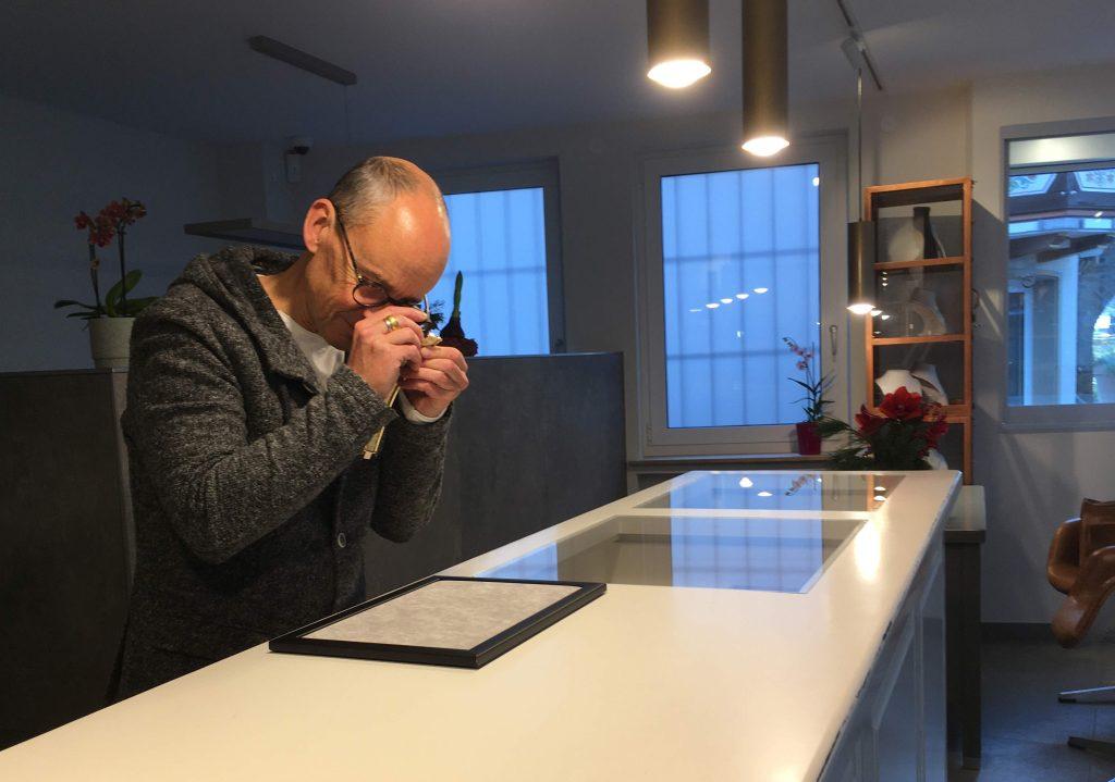 Der Inhaber von Schmuck am Ahrtor, Arnd Kulla, begutachtet Schmuckstücke